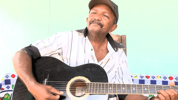 Morador Edvaldo Santos tocando violão